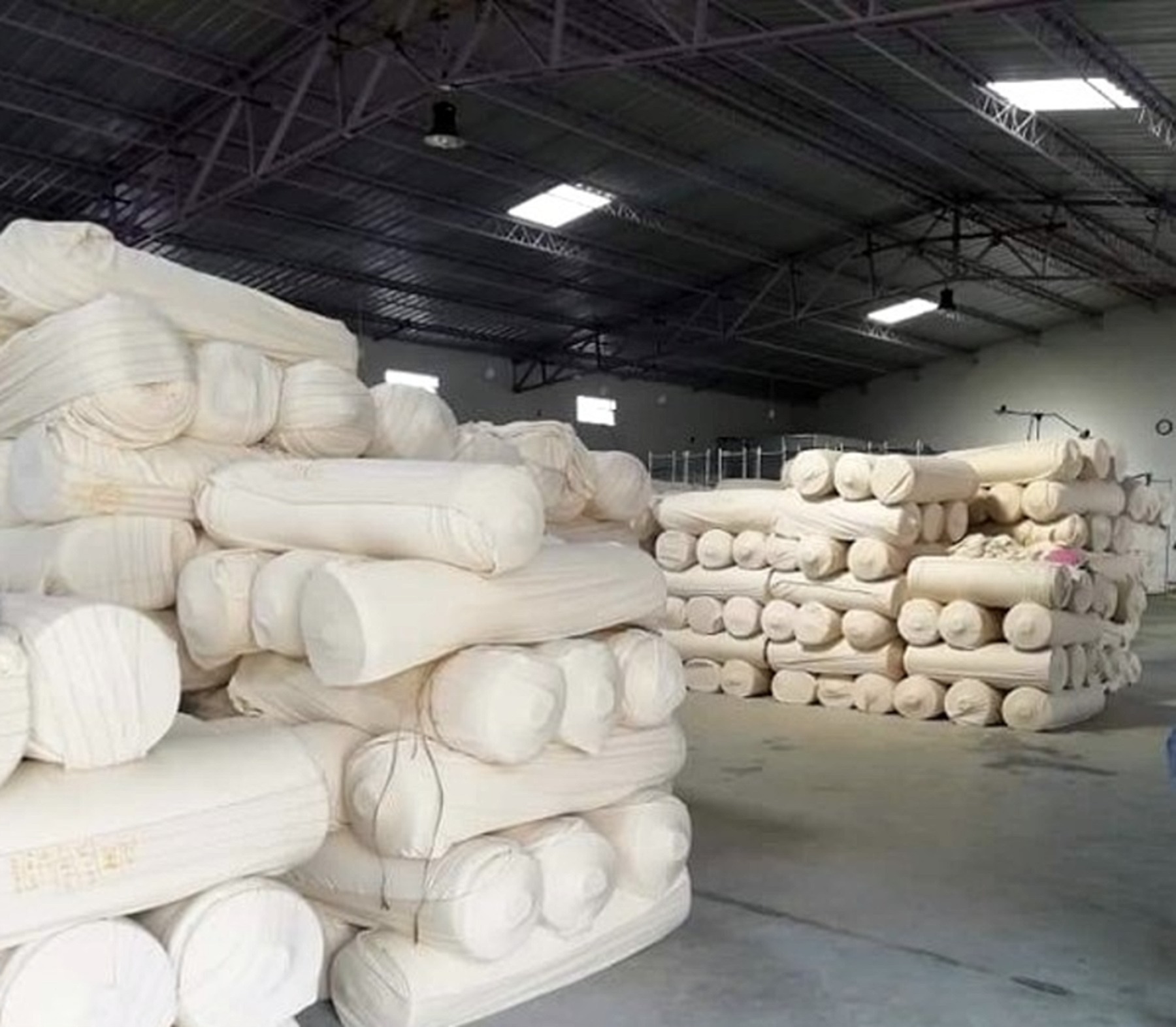 Finished rolls of cotton knitted fabric stacked in the warehouse